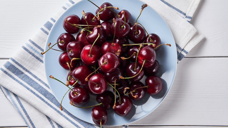 Ripe red cherries on blue plate