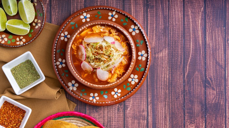 red pozole decorated dishware limes