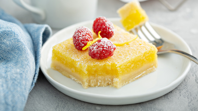 Lemon bar on plate with fresh raspberries