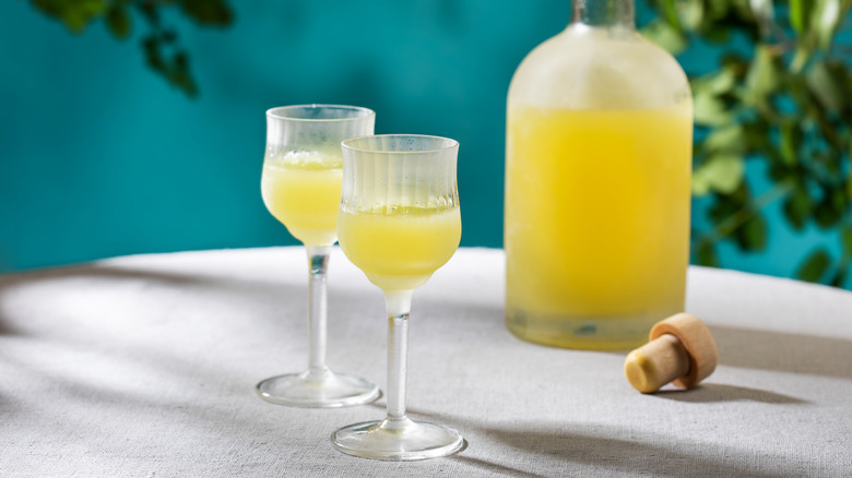 Two glasses of limoncello with bottle in background