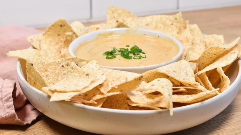 smoky white queso dip in serving platter with tortilla chips