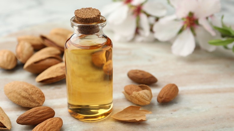 Bottle of almond extract surrounded by almonds