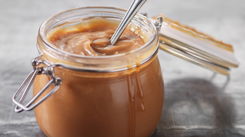 Jar of caramel sauce with spoon