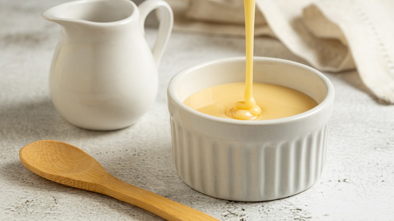 Pouring condensed milk into ramekin