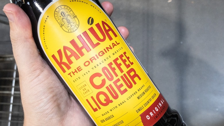 Hand holding bottle of Kahlua coffee liqueur