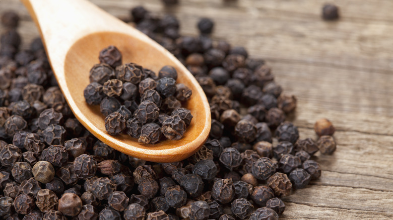 Black peppercorns with spoon