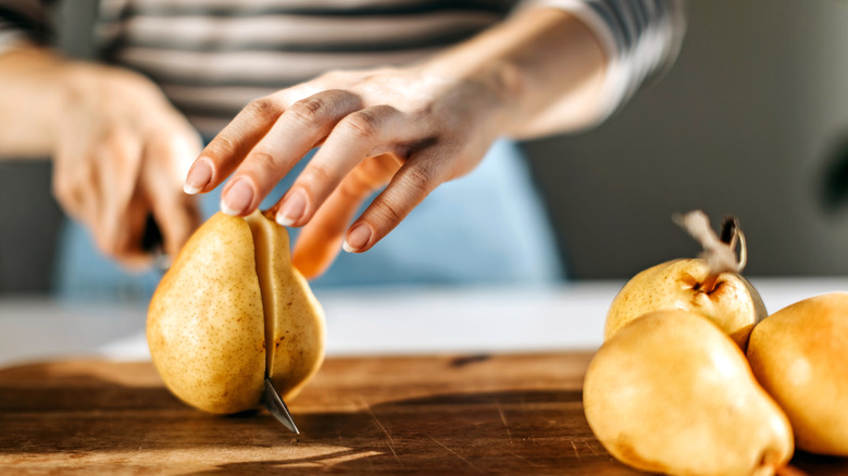 hands cutting pear