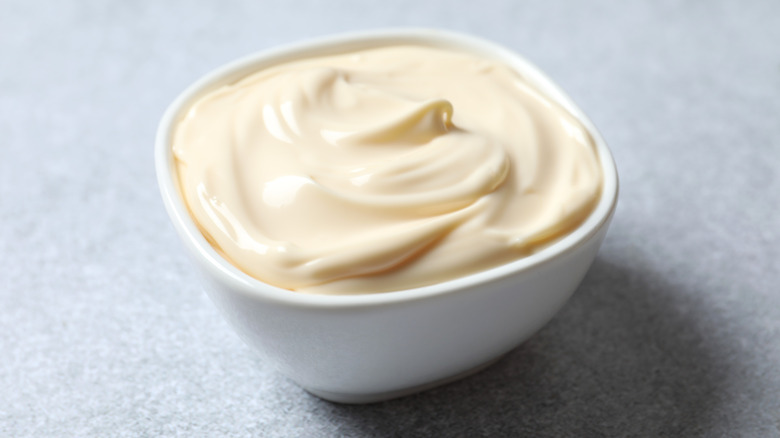 Close up of mayonnaise in white bowl on grey background