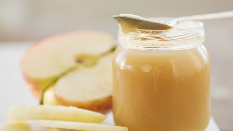 Applesauce jar and a cut apple
