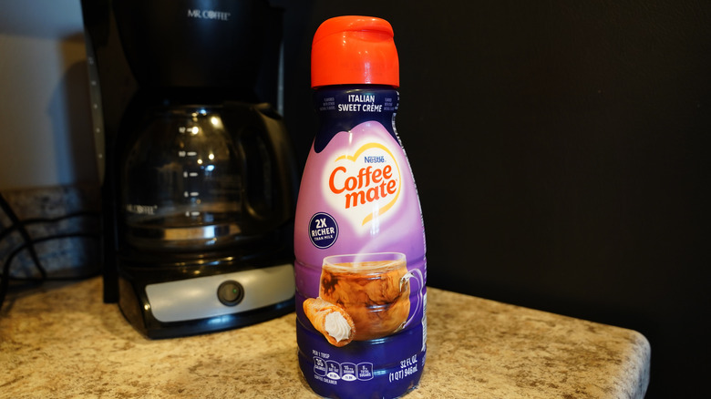 Coffee Mate flavored coffee creamer on kitchen counter in front of drip coffee maker