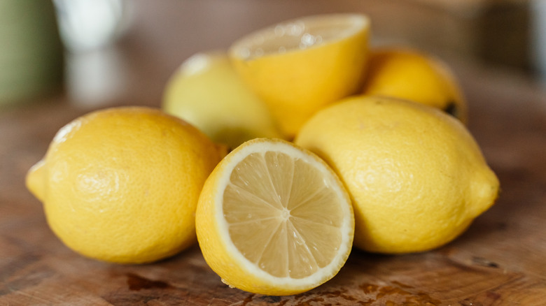 Whole and sliced lemons on wood table