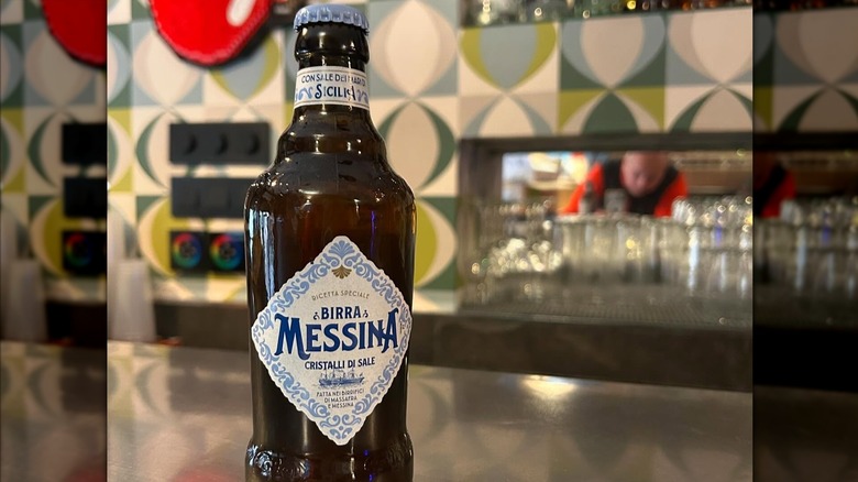 A bottle and a glass of Birra Messina Cristalli di Sale