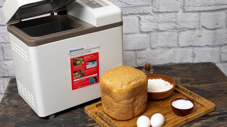 Bread Makers on a wooden table next to fresh loaf of bread