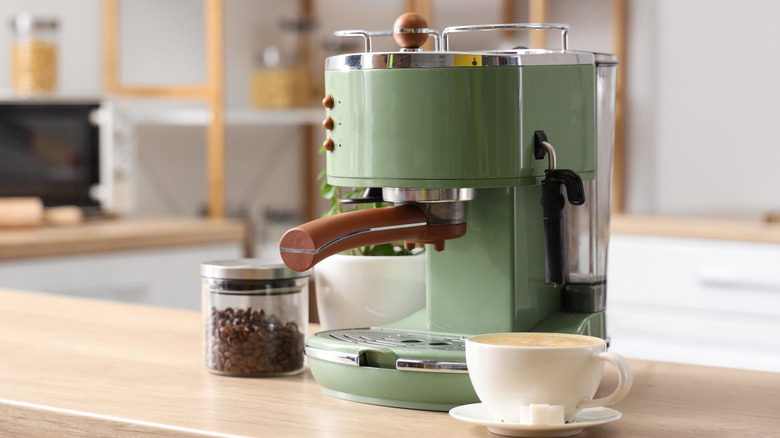 pale green espresso machine and latte sitting on kitchen counter