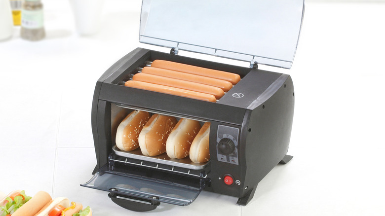 Hot dog toaster with hot dogs on top and buns toasting underneath
