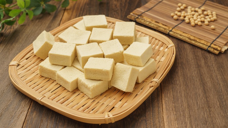 Blocks of tofu and soy beans on wooden table