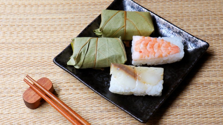 Oshi and kakinoha sushi with chopsticks