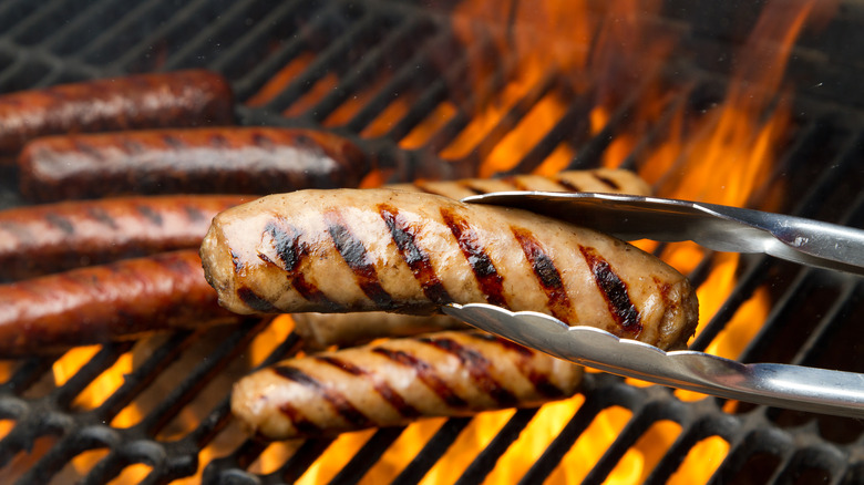 Flipping bratwurst on grill