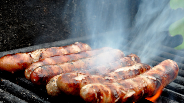 Grilling bratwurst on flame