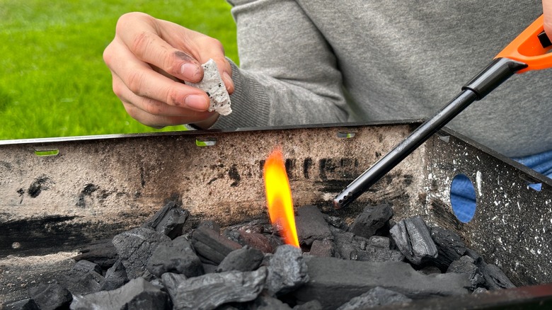 Person starting backyard grill