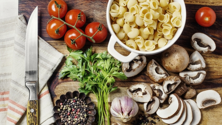 Ingredients are spread out on a wooden cutting board with a knife.