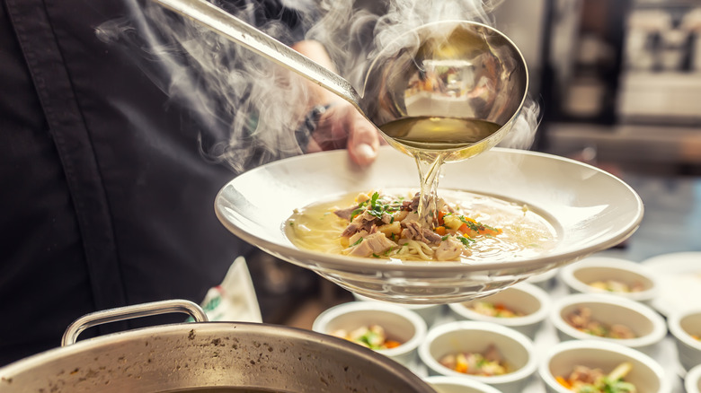 Soup being poured into a plate