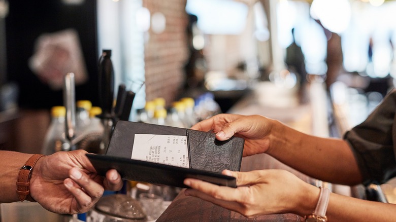 Waiter handing customer the bill