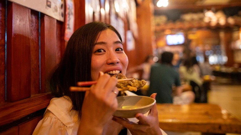 Woman eating with chopsticks