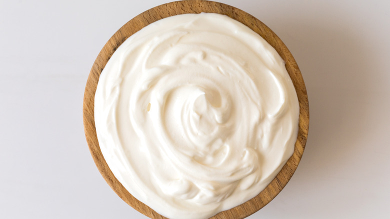 White yogurt in wooden bowl