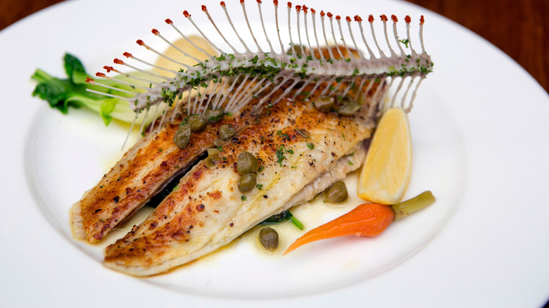 Sole meunière on white plate with vegetables
