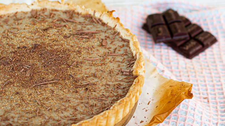'70s butterscotch tart ready to be enjoyed with a chocolate bar alongside on a table