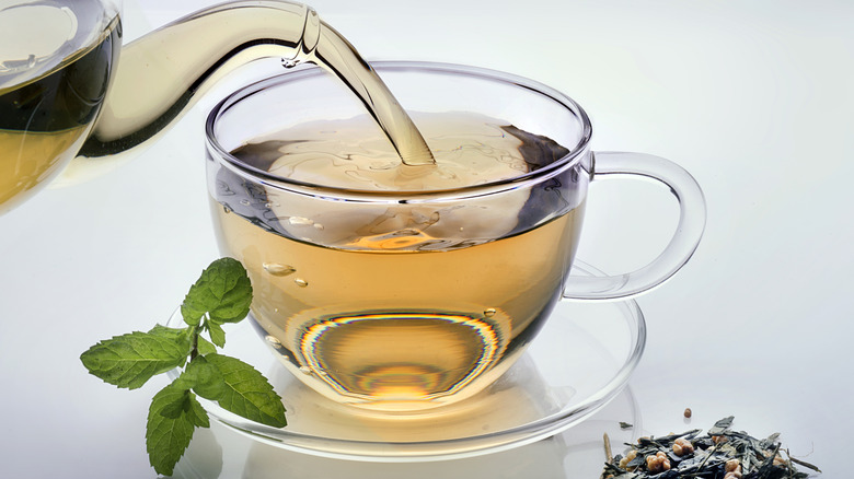 Green tea being poured into cup