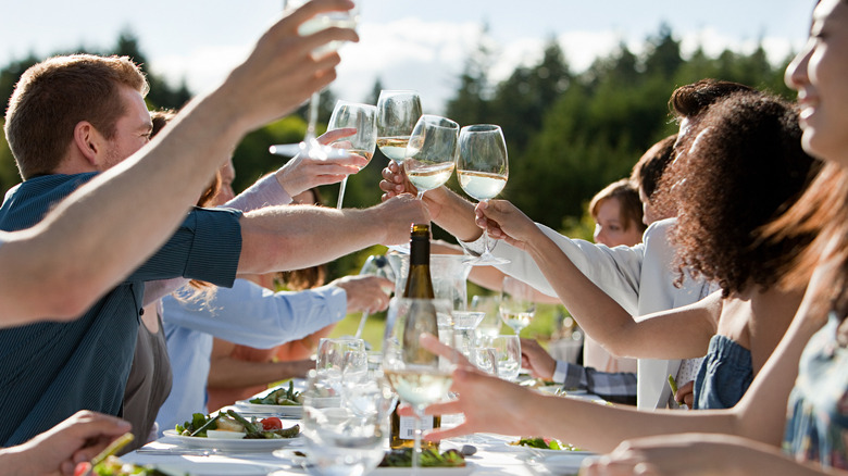 People clinking glasses with meal