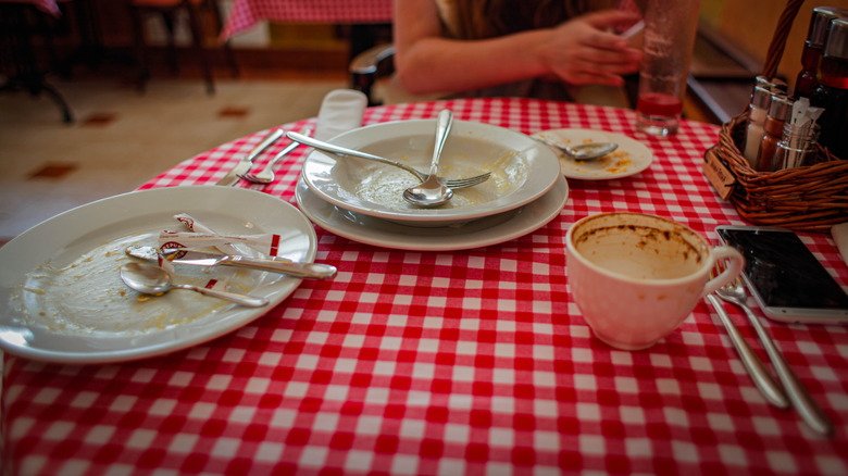 dirty dishes on checkered tablecloth