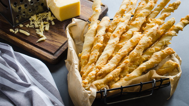 basket with breadsticks cheese on board