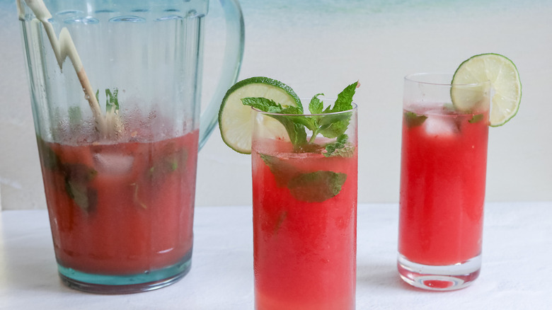 Watermelon mojito in pitcher by glasses