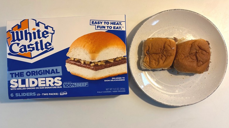 Two White Castle frozen original sliders on plate next to box of sliders