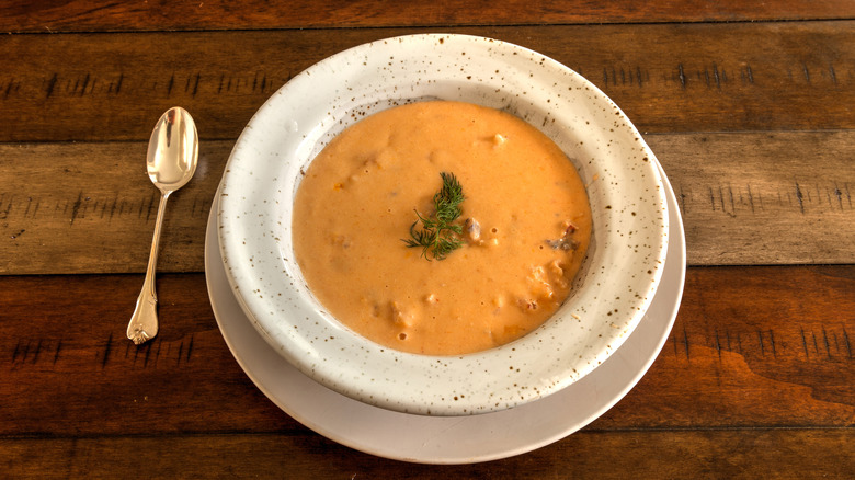 Seafood stew in white bowl on wooden table 