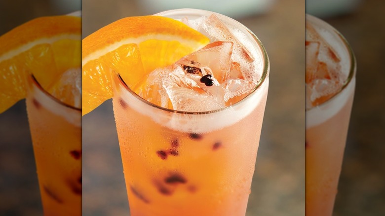 Peach colored drink with orange slice