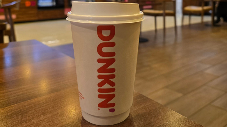 a cup of hot coffee from dunkin' on a table