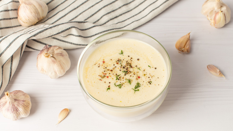 Bowl of aioli with garlic cloves