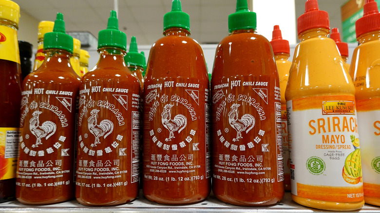 Bottles of sriracha lined up on store shelf