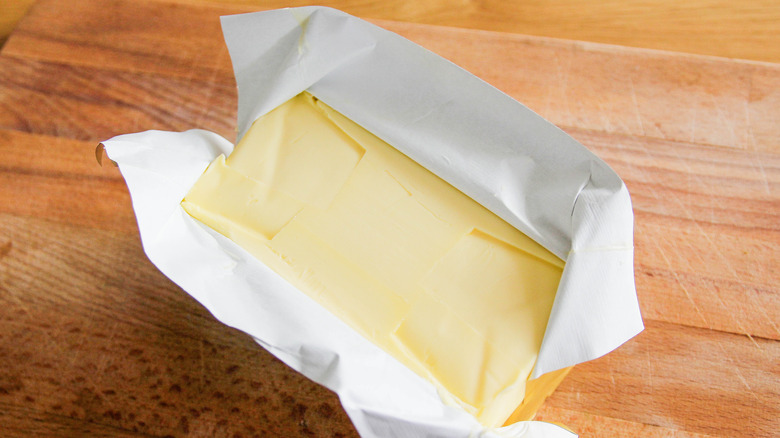 Opened butter wrapper on wooden table