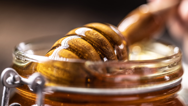 Honey in a mason jar with honey scoop