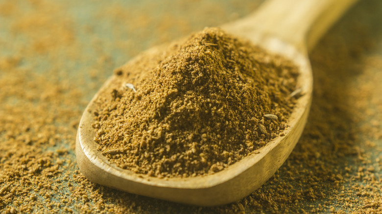 Cumin on a wooden spoon