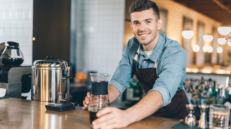 Barista holding coffee decanter