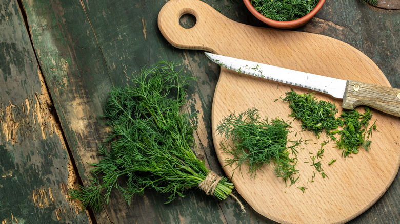 Chopping fresh dill on cutting board
