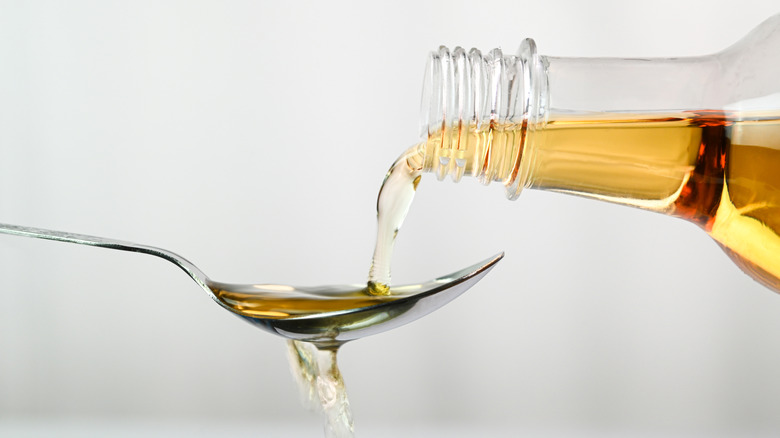 Pouring apple cider vinegar onto spoon