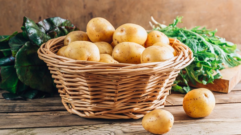Basket of potatoes with greens