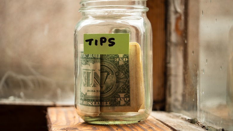 Tip jar filled with dollar bills